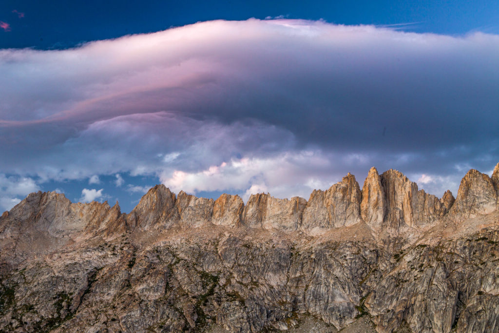 Soft pink clouds above a jagged granite ridgeline