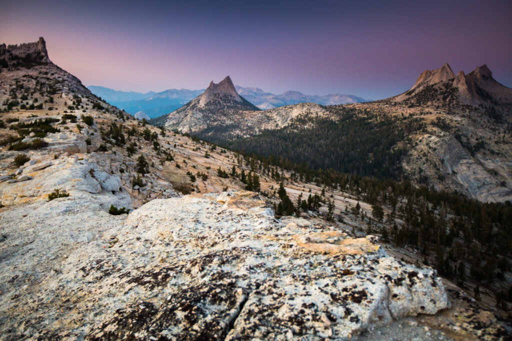 Granite mountain basin beneath a soft purple evening sky