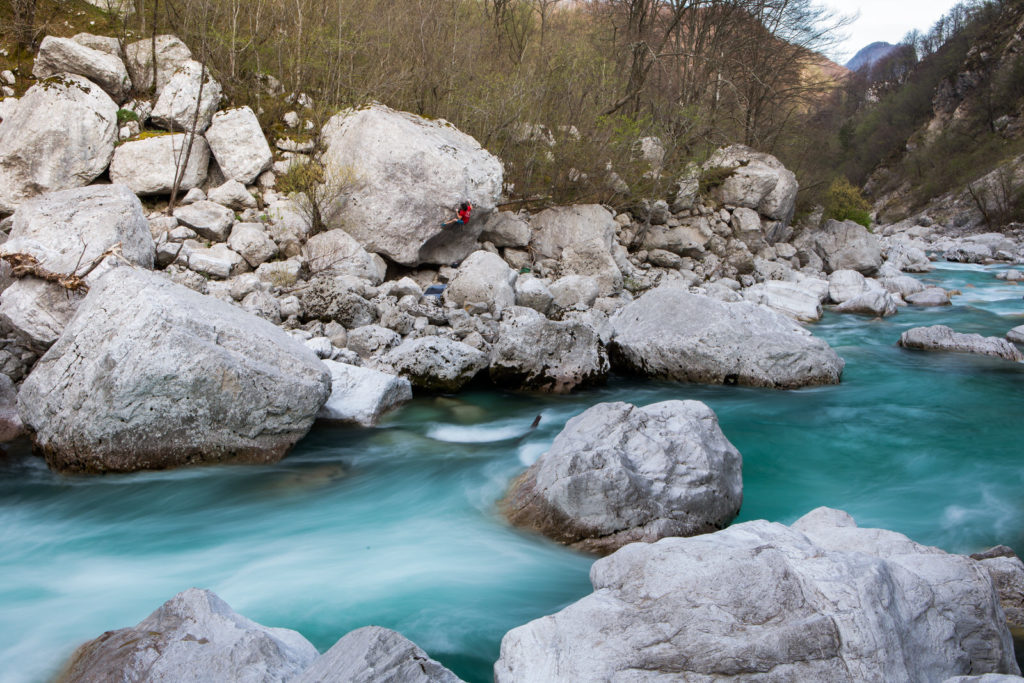 Turquoise river flowing between pale limestone boulders