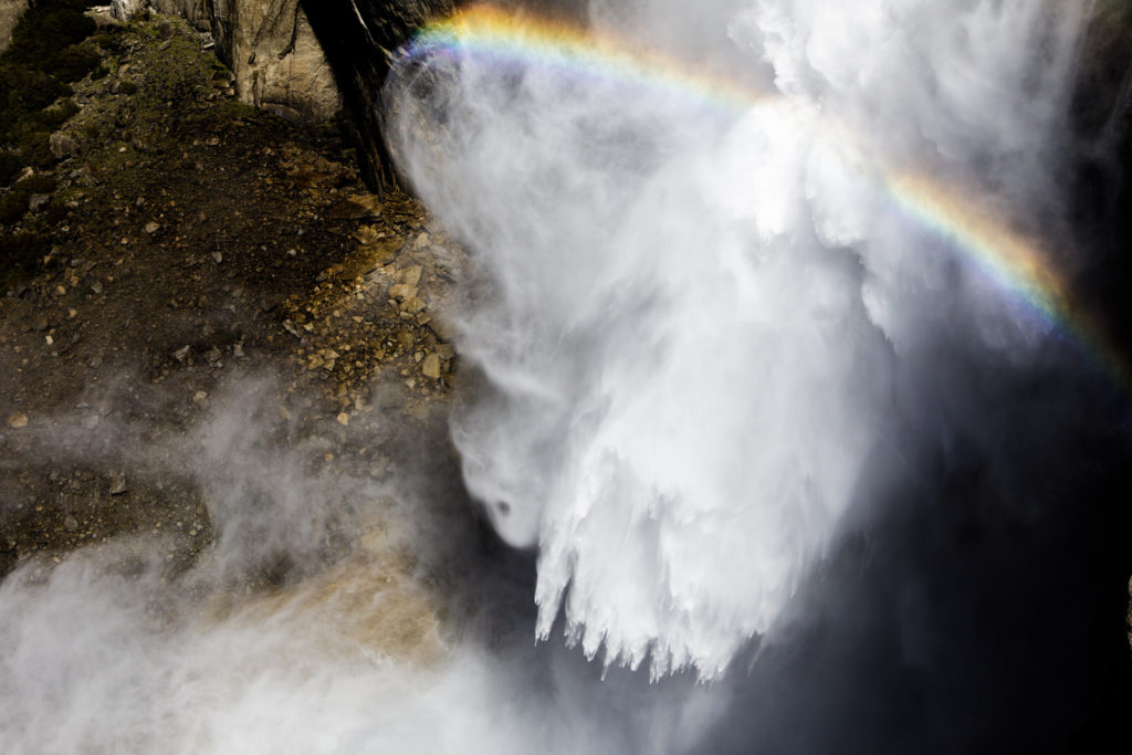 Rainbow crossing the spray of a powerful waterfall