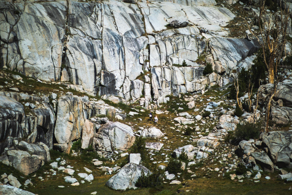 Wedding couple beneath a tall granite cliff