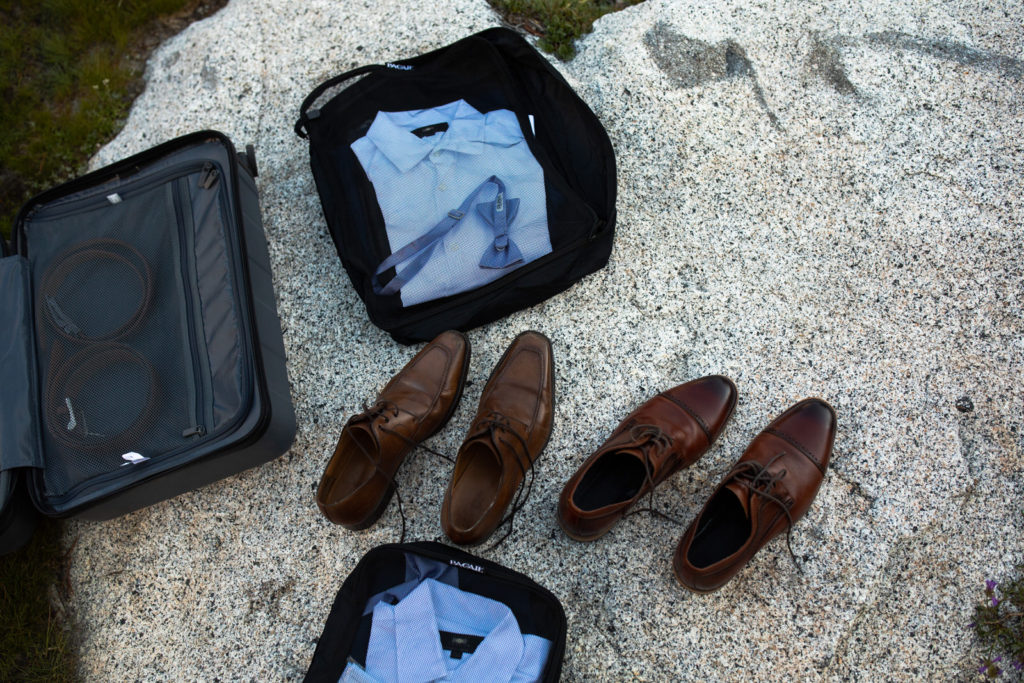 Dress shoes, shirt and tie laid out on granite at a campsite
