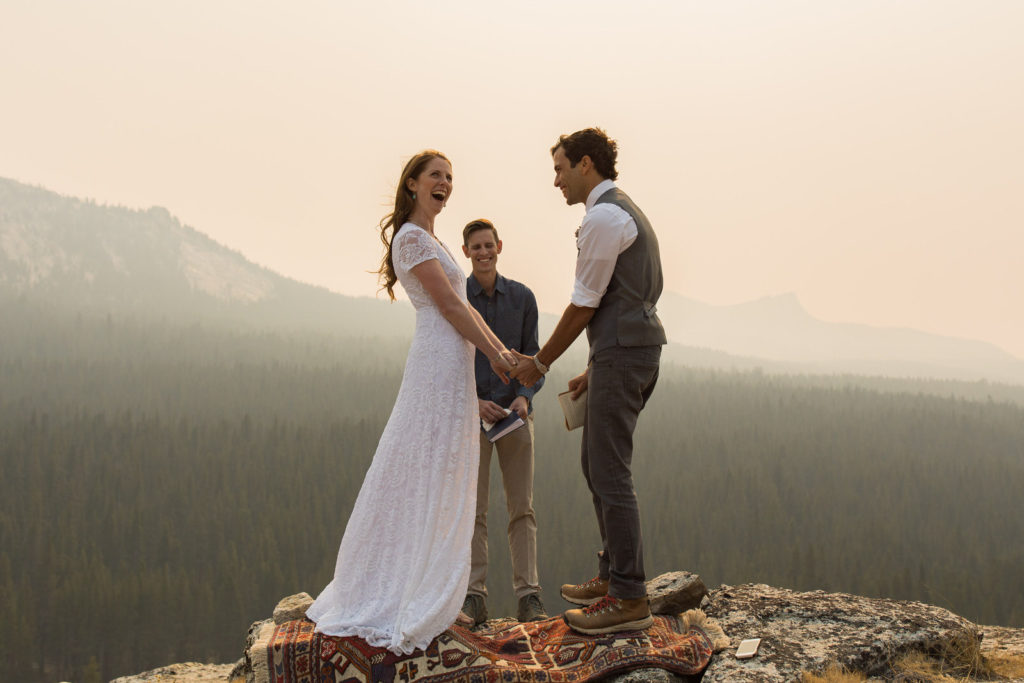 Couple holding hands on a patterned rug during their overlook ceremony