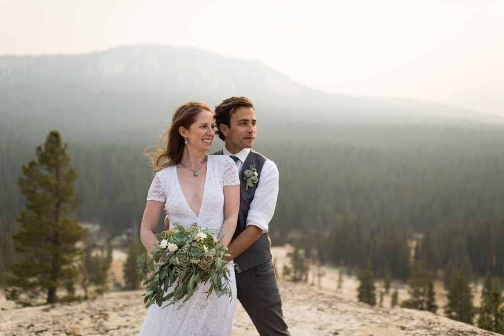 Bride and groom smiling together with a hazy mountain backdrop