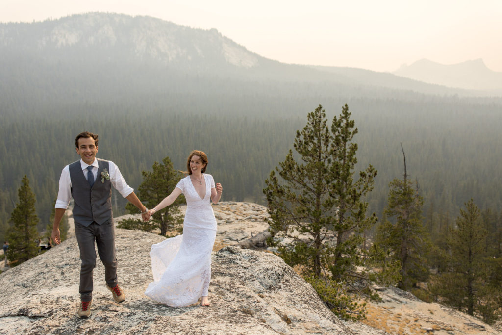 Bride and groom walking together on a mountain overlook