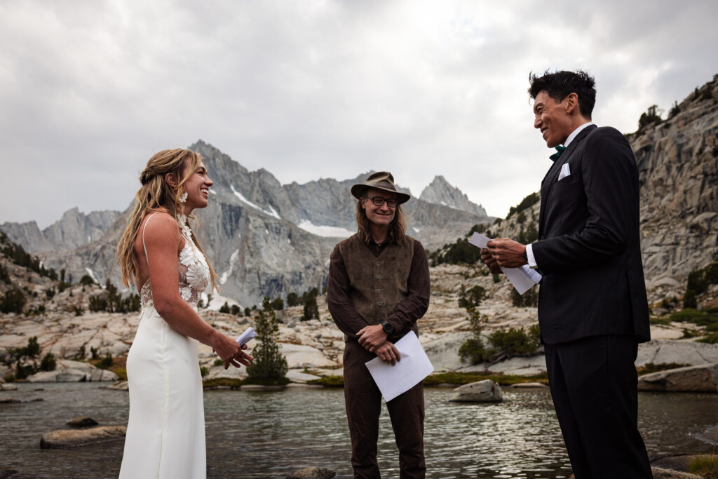 Groom reading his vows while the bride and officiant listen