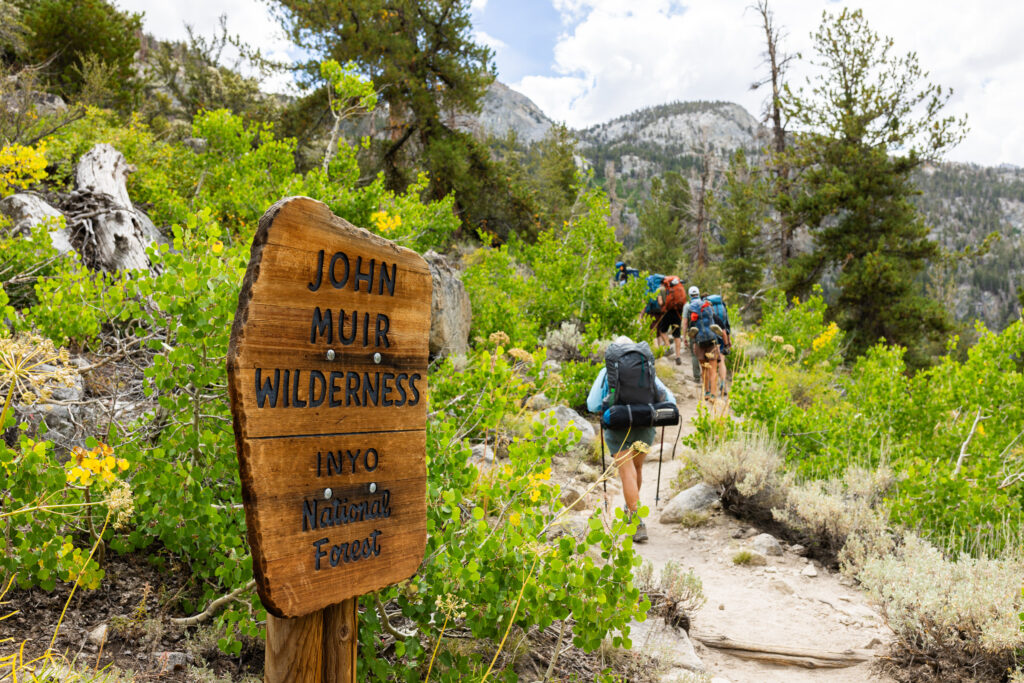 Backpackers passing a John Muir Wilderness sign