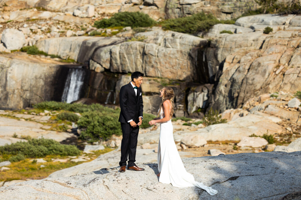 Couple standing together beside a granite waterfall