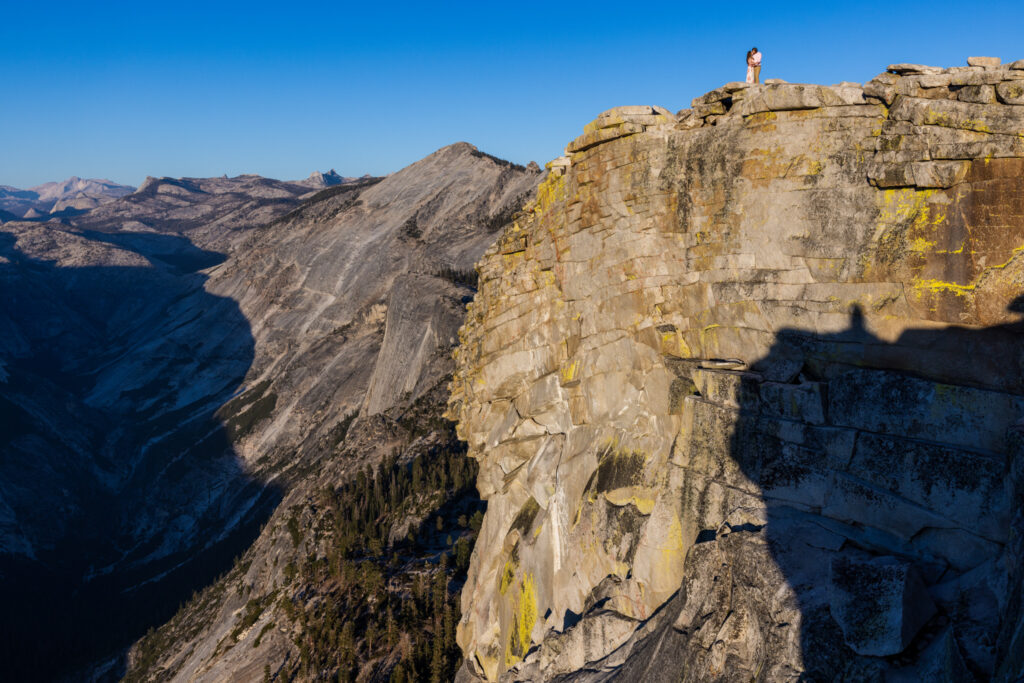 Distant figure standing on a sheer granite overlook