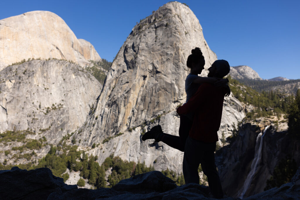 Silhouetted couple embracing in front of towering granite formations