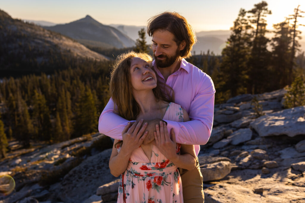 Couple smiling together on a mountain overlook in evening light