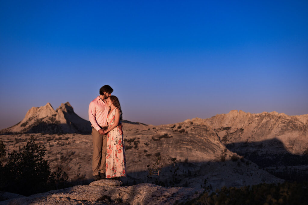 Couple embracing on a mountain ridge in warm evening light
