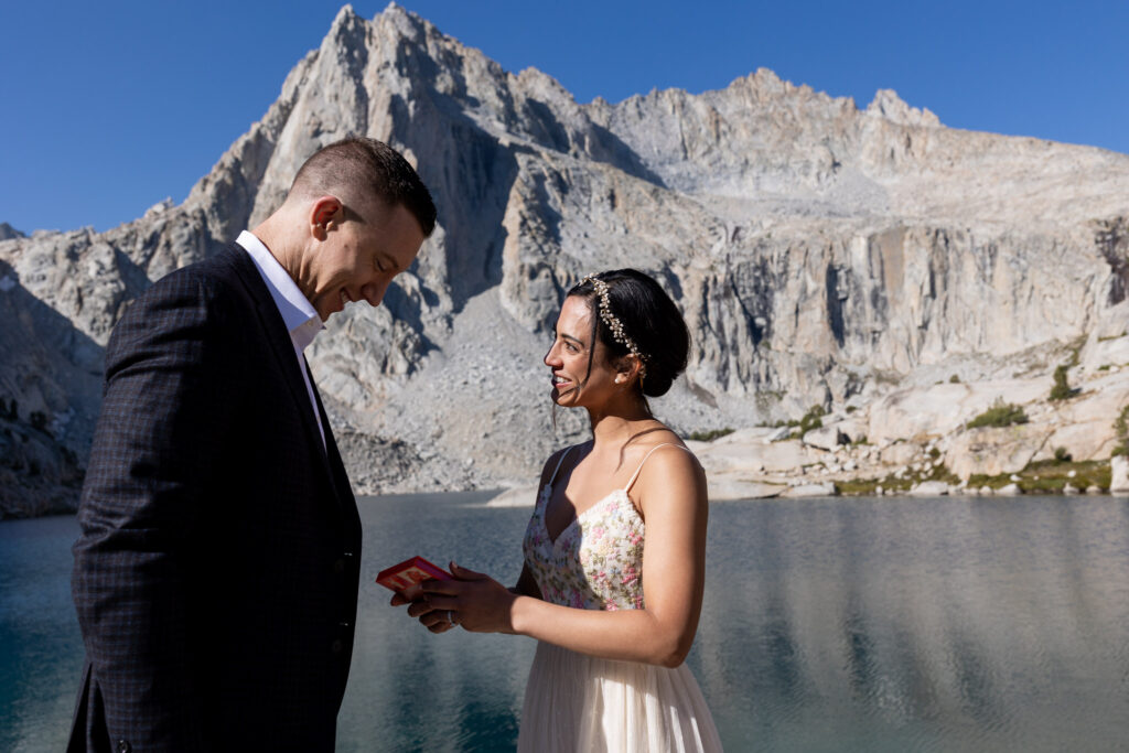 Bride reading her vows to the groom beside an alpine lake