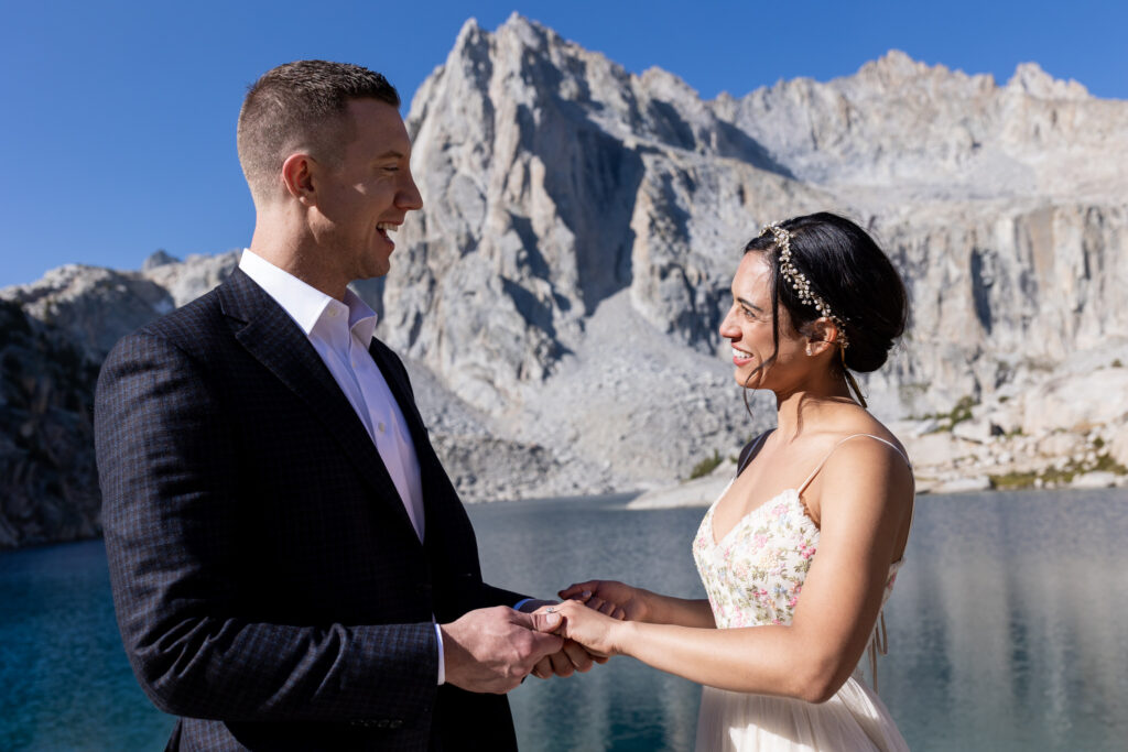 Bride embracing the groom beneath a granite mountain peak
