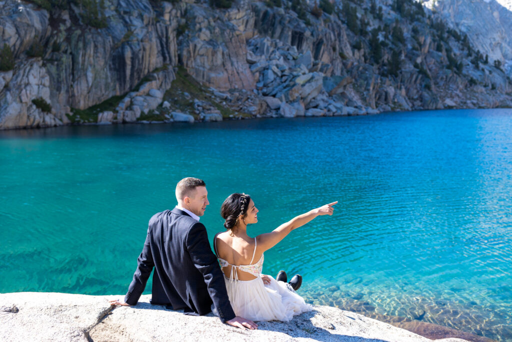 Couple looking across a turquoise alpine lake