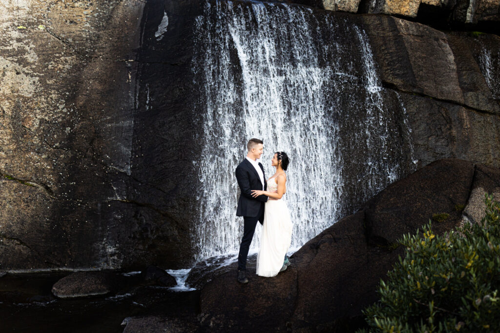 Couple embracing in front of a waterfall